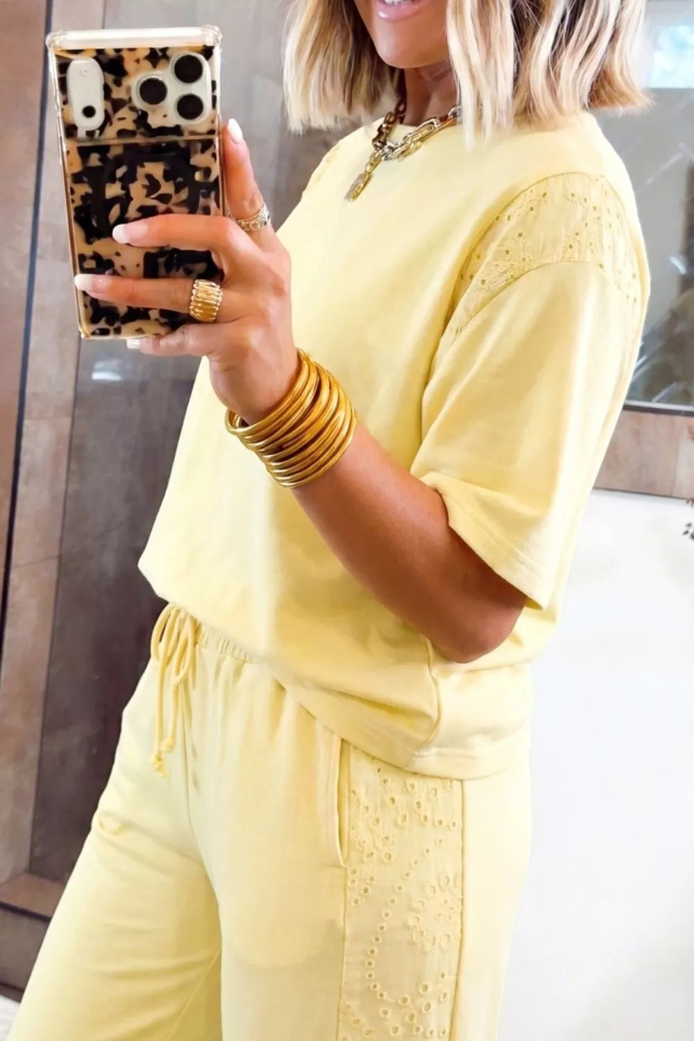 Trendsi rings set featuring a half sleeve top and drawstring pants with shiny, interconnected ring details on the fabric.