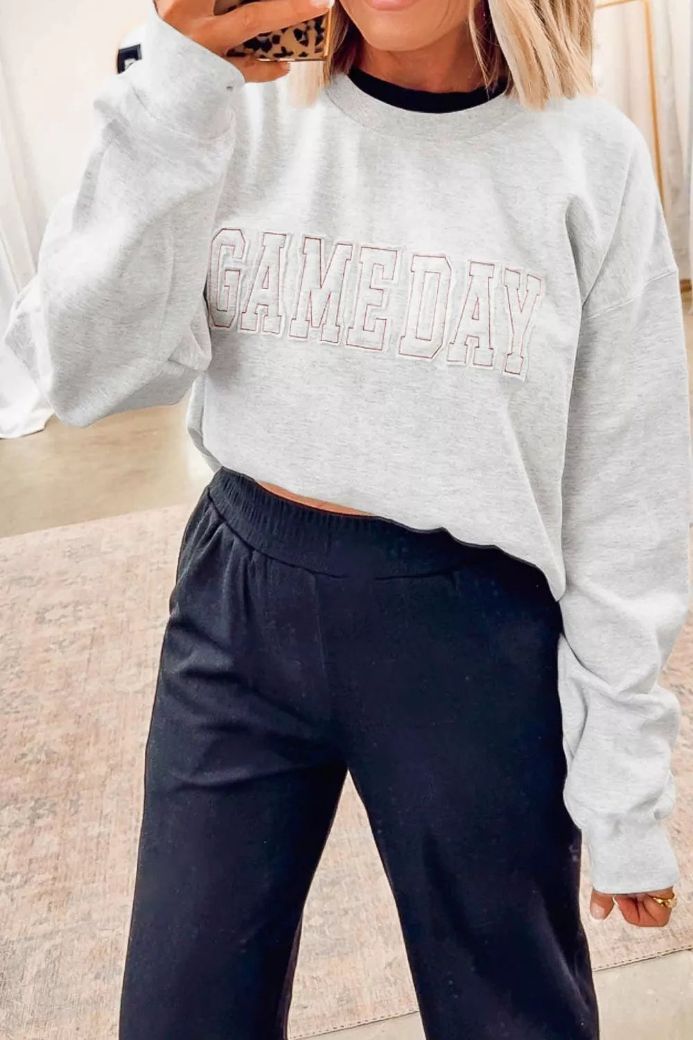 Women's letter embroidered long sleeve round neck sweatshirt from Trendsi, featuring a cozy fit and stylish embroidery detail.