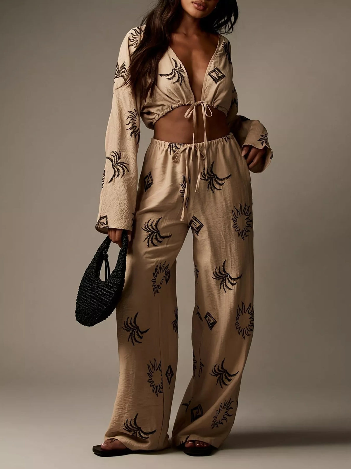 Printed crop top and wide-leg pants set for women by Trendsi, featuring colorful floral patterns and comfortable fit.