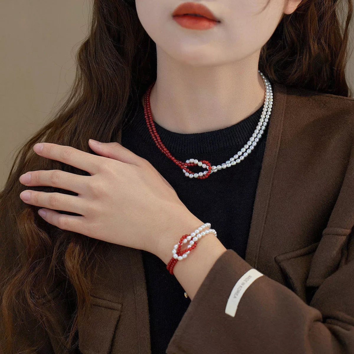 Double layered knot necklace from Plush Fashion Hub featuring intertwined chain design on a neutral background.