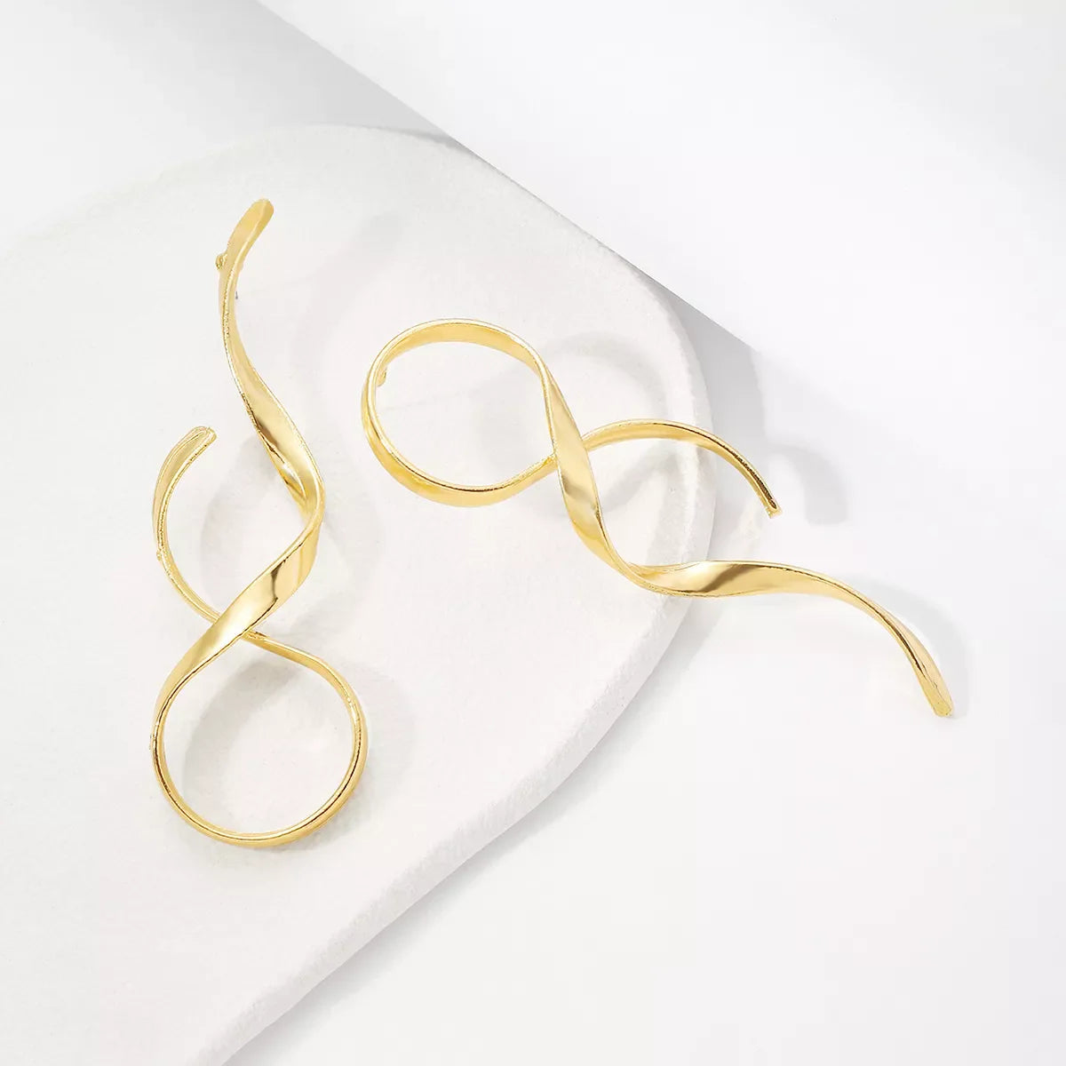 Plush Fashion Hub alloy spiral drop earrings featuring sleek, twisting metal design hanging from standard earring hooks.
