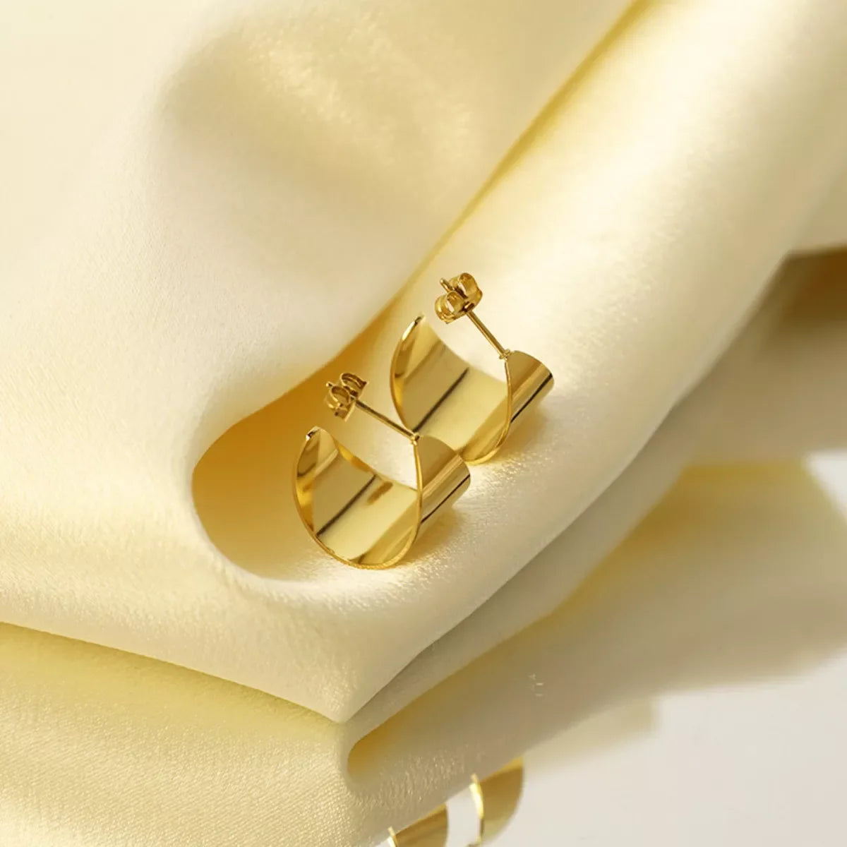 18K gold-plated stud earrings with a sleek, polished finish, showcasing elegant jewelry design for women.