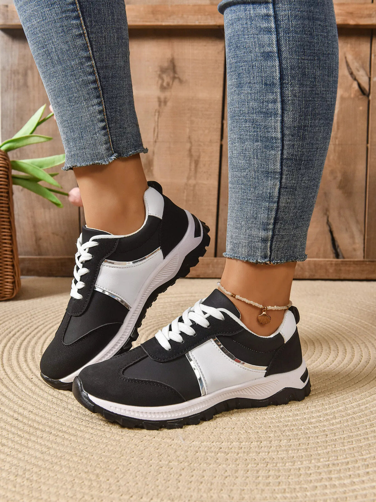 Contrast lace-up sneakers from Trendsi featuring a stylish design, white soles, and black and white lace details.