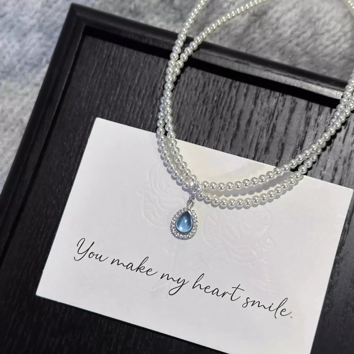 Double layered pearl necklace with teardrop pendant featuring lustrous pearls and elegant design by Plush Fashion Hub.