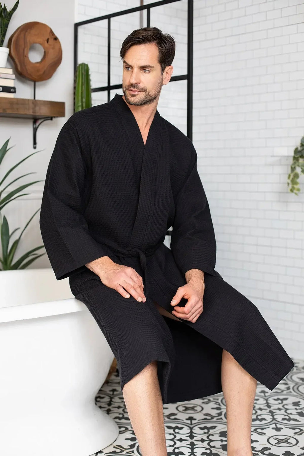 Men's Lotus Linen waffle spa bathrobe made of absorbent, lightweight cotton, shown hanging with a soft, textured fabric.