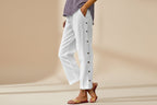 FitiqueFit casual cropped pants with decorative buttons along the side seams, showcasing a stylish, modern design.