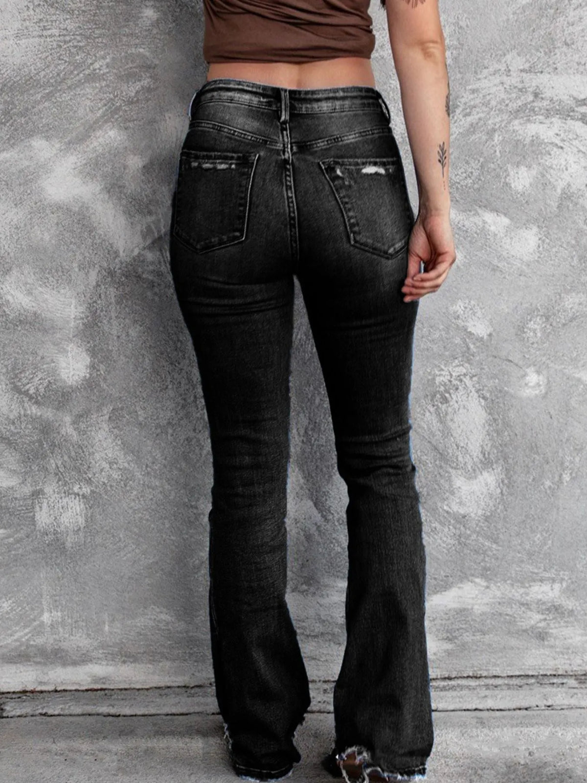 Distressed flare denim jeans by Plush Fashion Hub with ripped details and wide-leg fit on a neutral background.