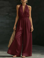 Women’s V-neck halter neck wide-leg jumpsuit by FitiqueFit, casualwear style, shown in a relaxed fit with flowing fabric.
