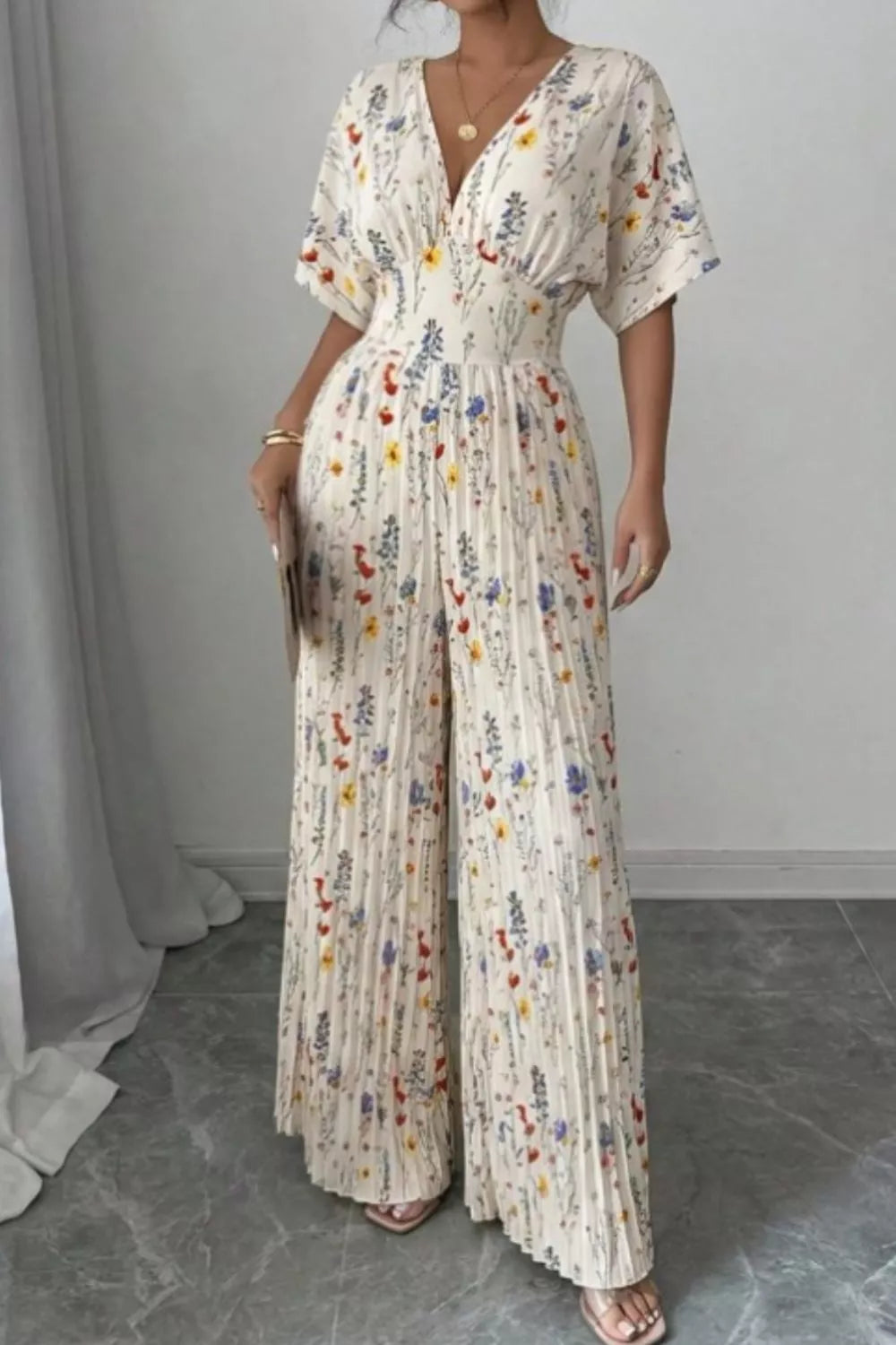 Floral print wide-leg pleated jumpsuit from Plush Fashion Hub featuring a stylish design and flowing fabric.