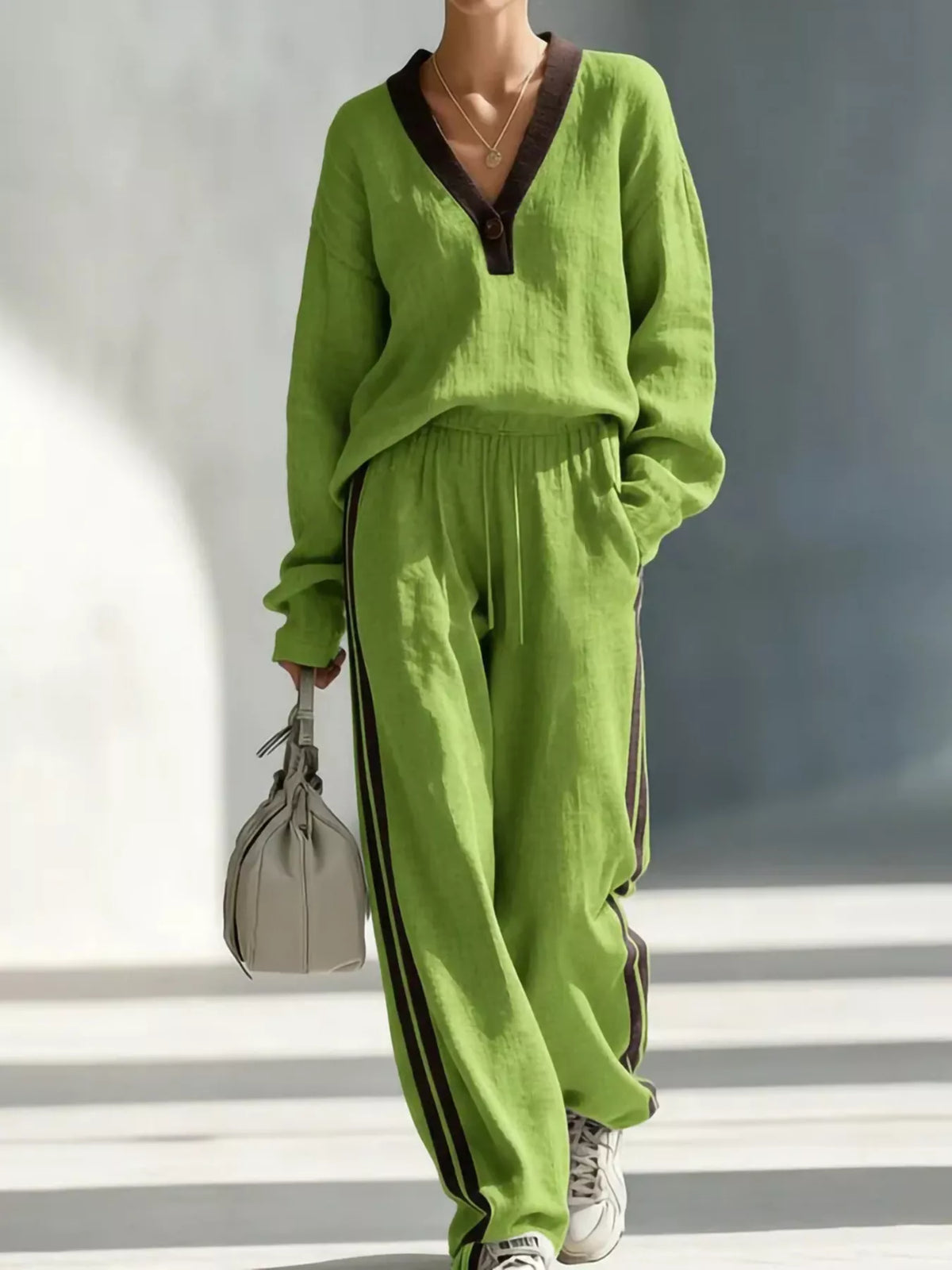 Women's contrast V-neck top and striped pants set from Trendsi, featuring a stylish coordinated outfit with contrasting colors.