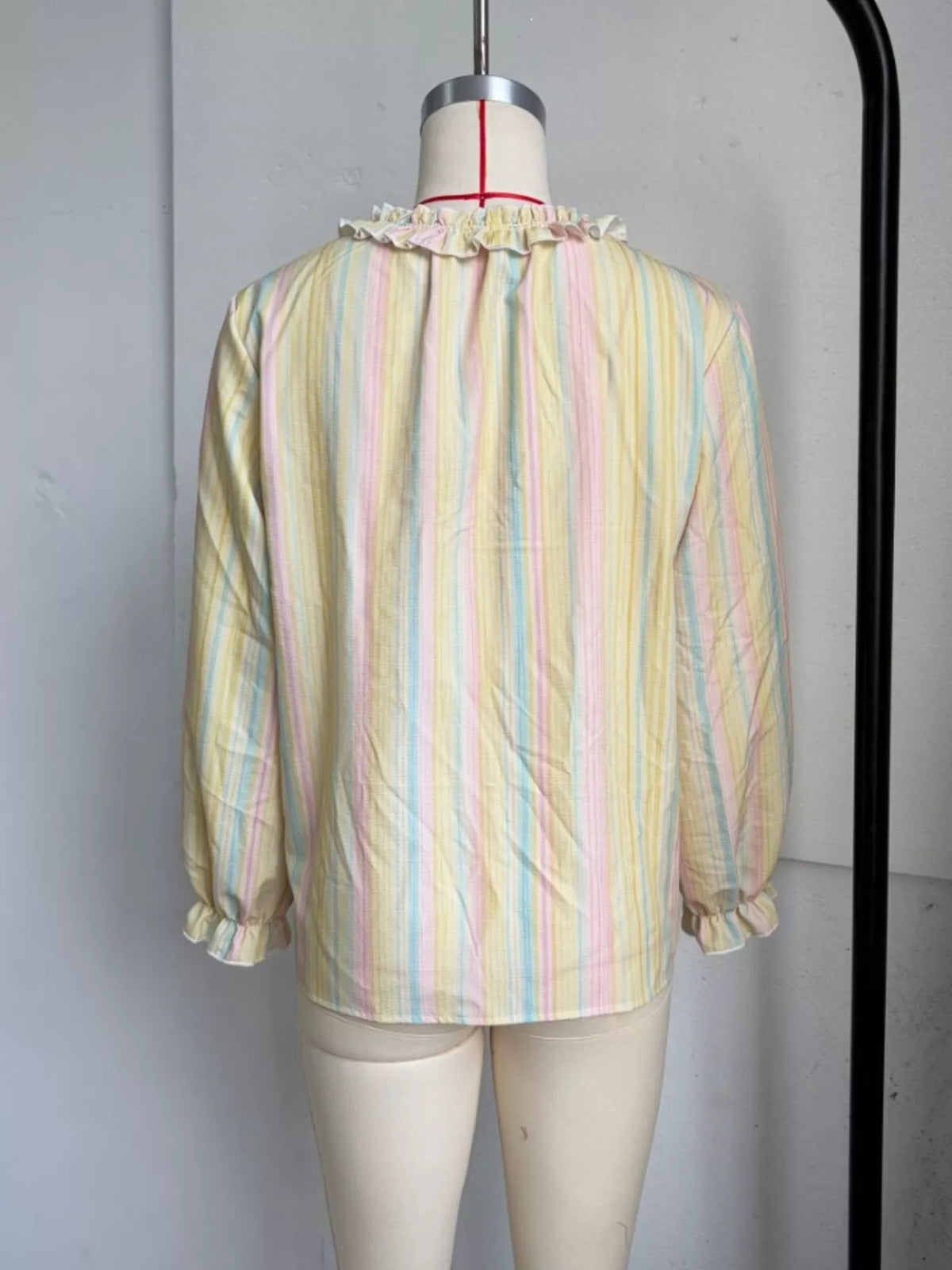 Striped ruffle-trim V-neck blouse from Trendsi featuring a feminine design and lightweight fabric, shown on a white background.