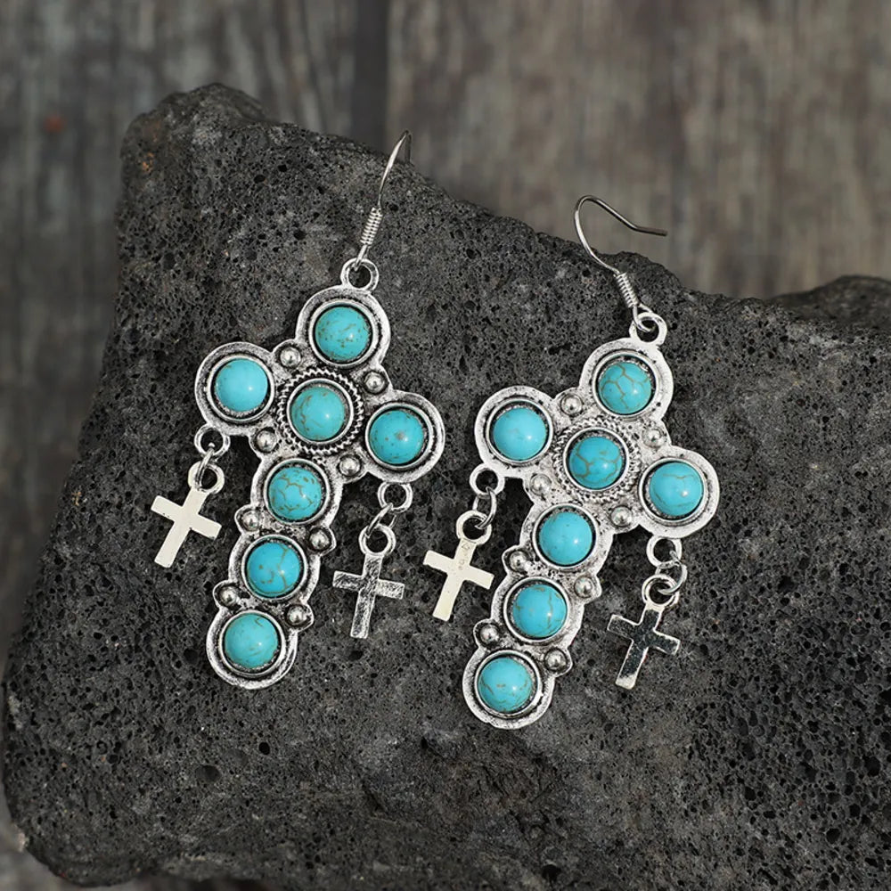 Artificial turquoise cross shape earrings by Plush Fashion Hub featuring vibrant blue cross design on silver-tone hooks.