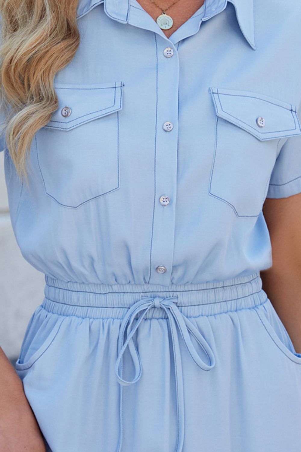 Blue denim dress with drawstring waist, collared neck, and short sleeves from Plush Fashion Hub, displayed on a hanger.