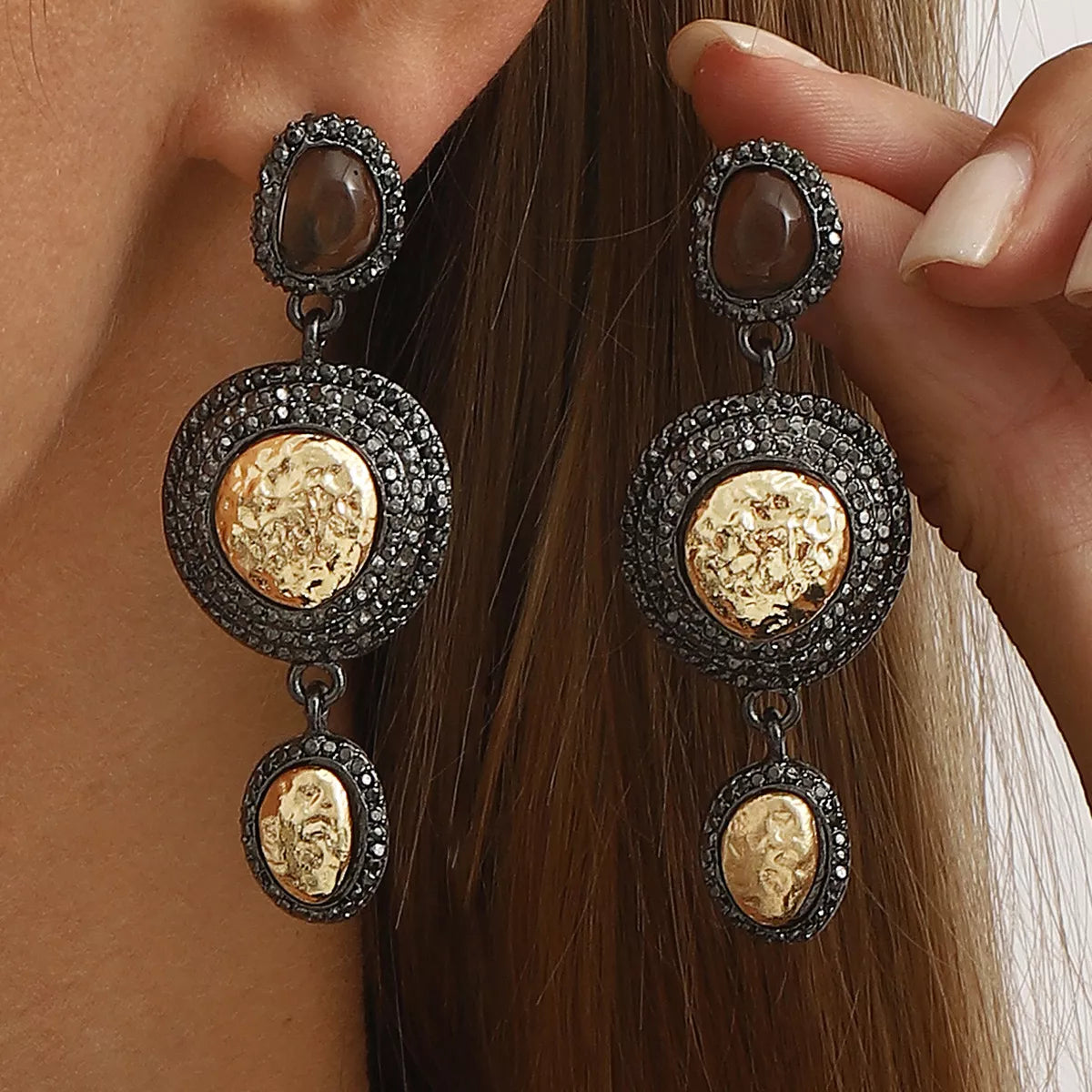 Vintage-inspired gold dangle earrings with intricate design details, featuring plush fashion hub branding.