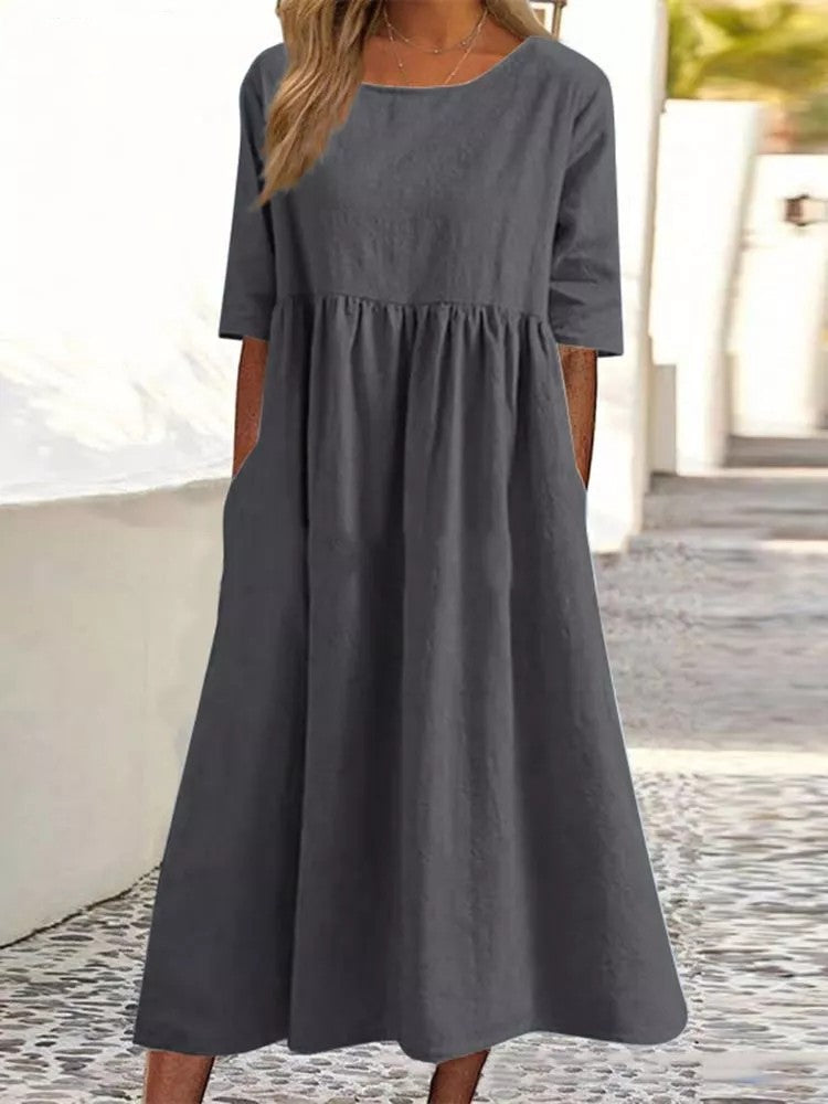 Plus size midi casual dress by FitiqueFit with a round neckline and front pockets, shown on a model.