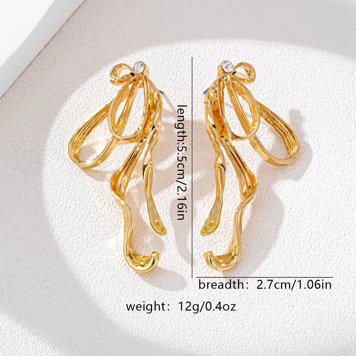 Gold-plated bow earrings, stylish jewelry accessory, featuring delicate design and shiny finish, perfect for elegant outfits.