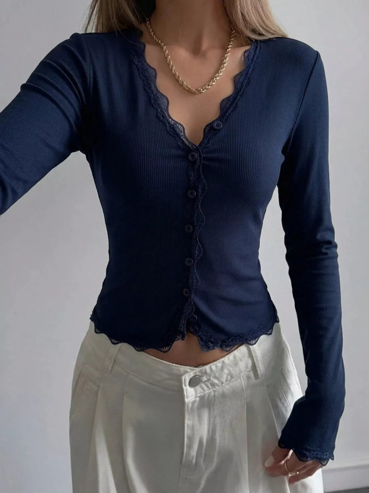 Ribbed long sleeve blouse with lace trim and V-neck, stylish women's blouse by Trendsi, featuring textured fabric and feminine details.