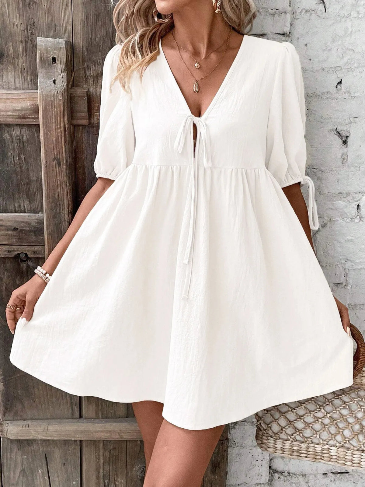 Cotton V-neck tie-front mini dress with puff sleeves by Plush Fashion Hub, featuring a stylish design and comfortable fit.
