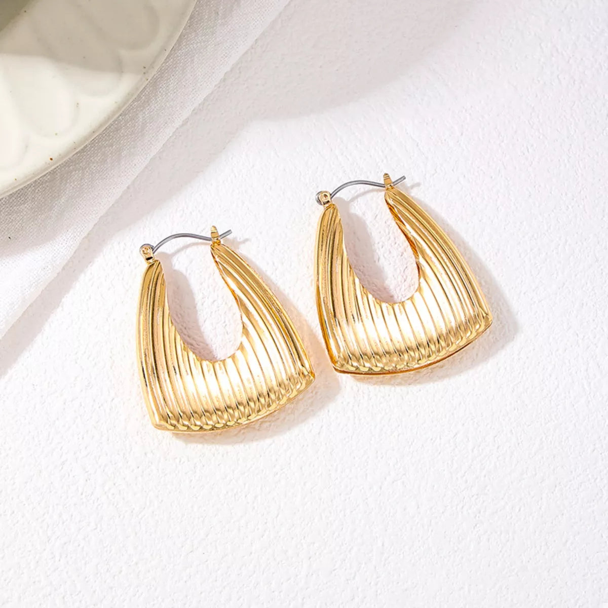 Gold-plated alloy ribbed triangular hoop earrings with a modern design, perfect for stylish accessory wear.
