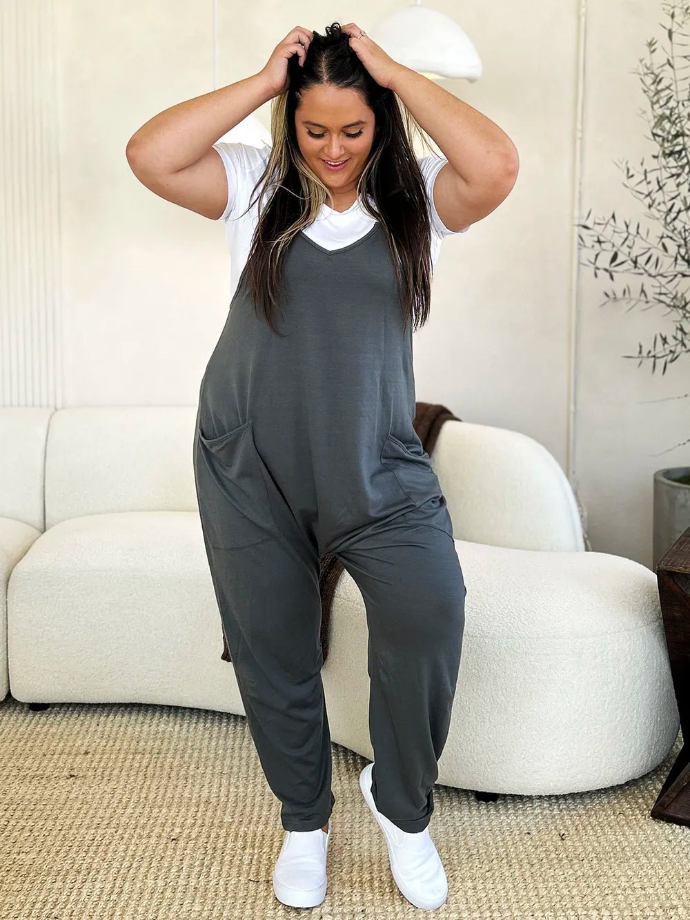 Women’s sleeveless V-neck wide-leg jumpsuit with pockets by Plush Fashion Hub, shown in a full-length view.