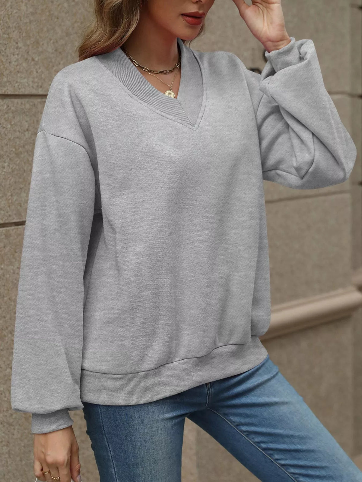 V-neck solid color casual sweatshirt by Trendsi, showing a comfortable fit and simple design in soft fabric.