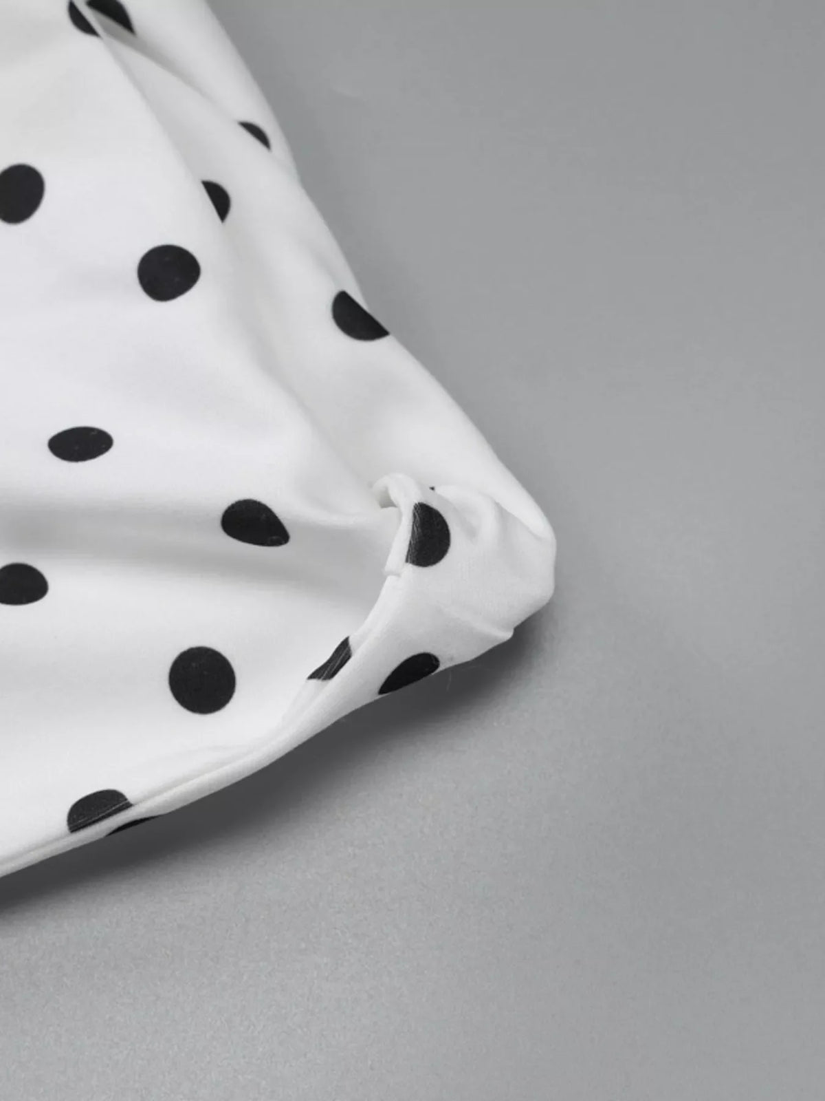 Polka dot sleeveless mini dress with bow accents by Plush Fashion Hub, featuring a playful pattern and stylish design.