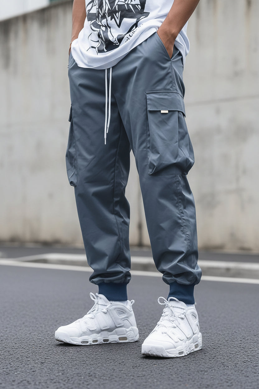 Men’s streetwear cargo pants with multiple pockets, drawstring waist, by FitiqueFit, shown in a casual urban style.