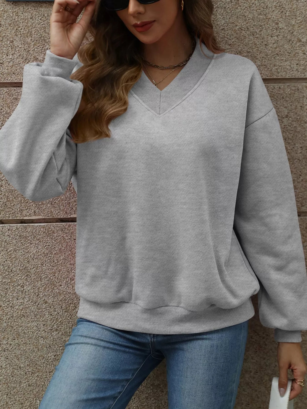 V-neck solid color casual sweatshirt by Trendsi, showing a relaxed fit with long sleeves and a comfortable neckline.