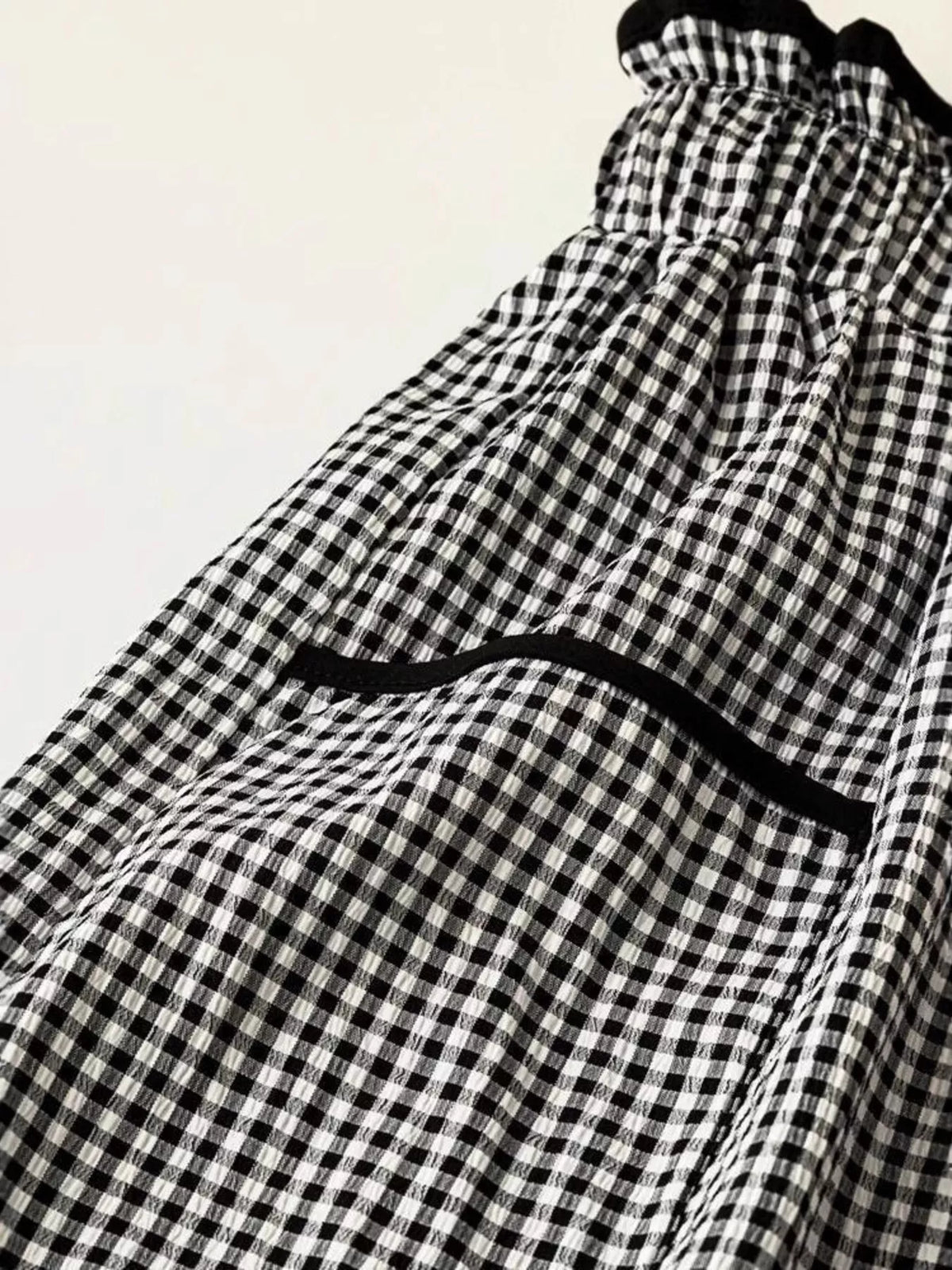 Women’s high-waisted gingham wide-leg pants with pockets by Plush Fashion Hub, shown in a stylish black and white checked pattern.