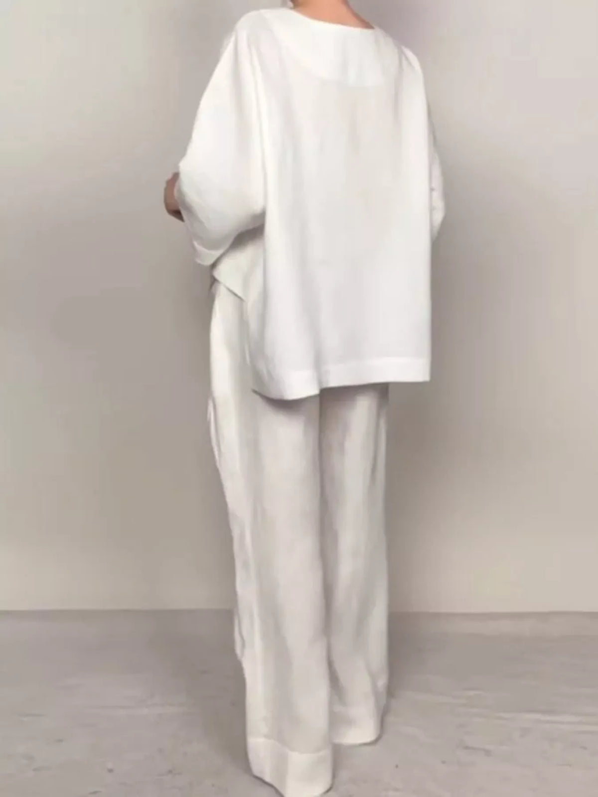 Plus size full V-neck long sleeve top and pants set by Trendsi, featuring a comfortable matching outfit with a stylish V-neck design.