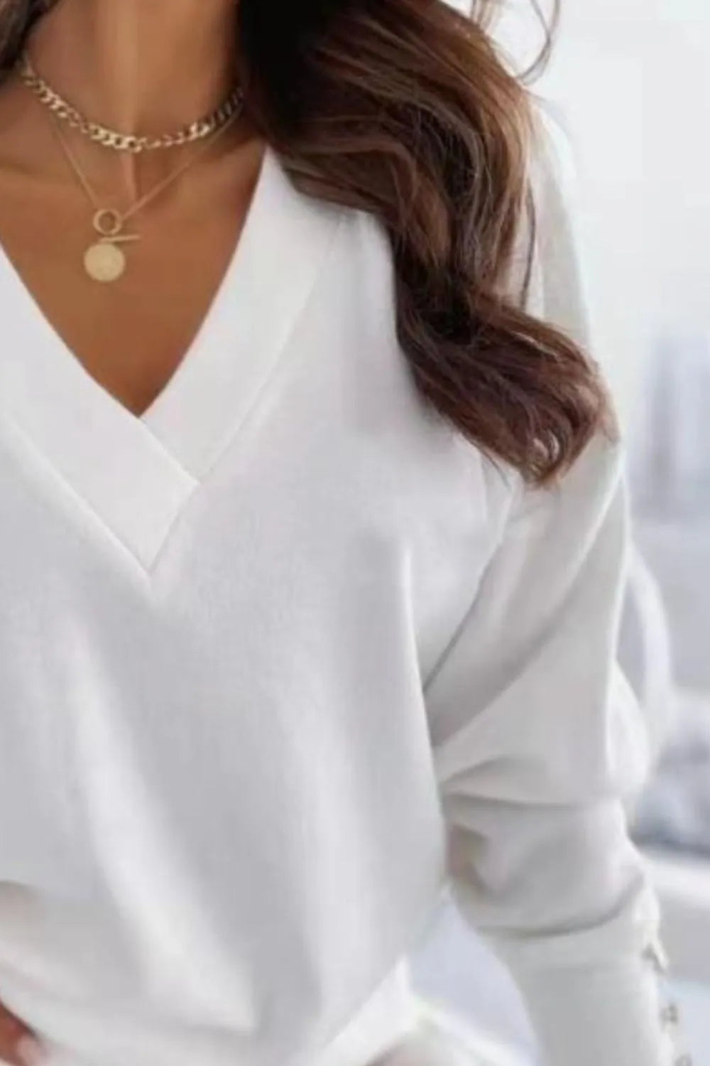V-neck long sleeve sweatshirt by Trendsi, soft and comfortable casual top in a neutral color, with a relaxed fit and ribbed cuffs.