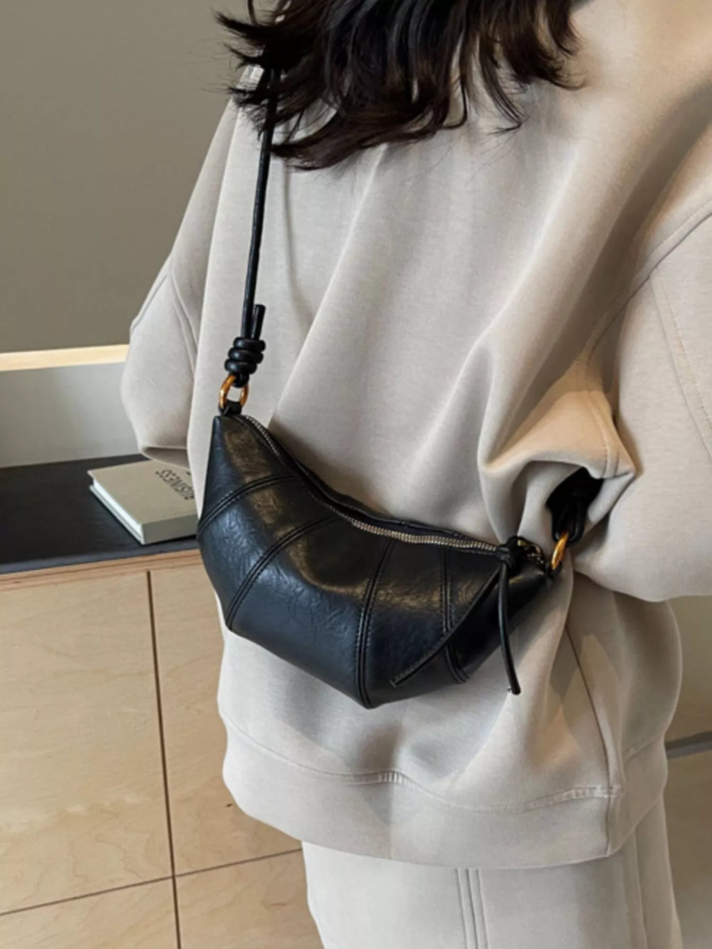 Croissant-shaped Trendsi crossbody bag featuring a soft, realistic croissant design with a slim strap and stylish details.