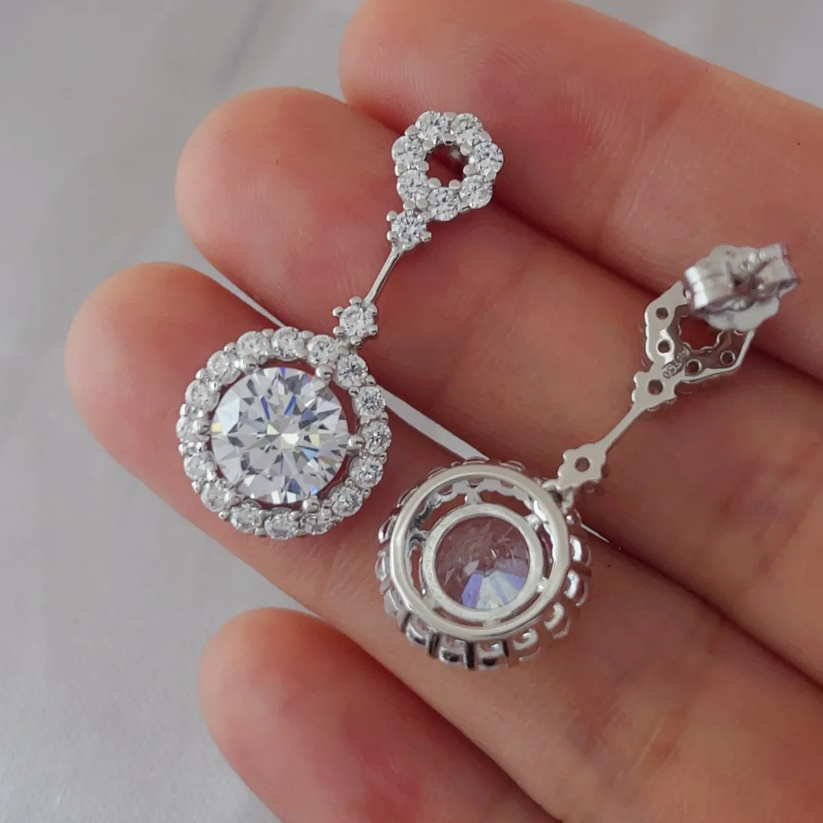 Four-carat crystal drop earrings with round halo design featuring dangle style, from Plush Fashion Hub, showcasing sparkling crystal details.