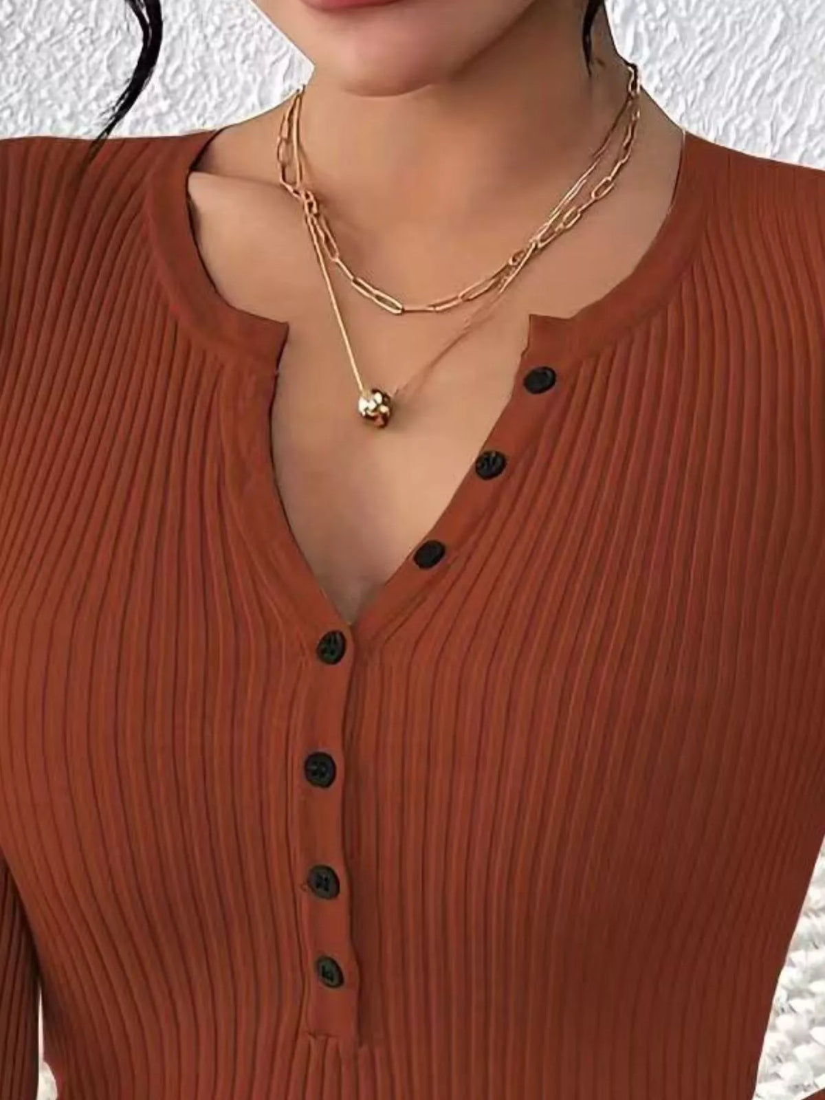 Ribbed knit button-front top in soft fabric, displayed on a mannequin, featuring a fitted silhouette and classic ribbed texture.