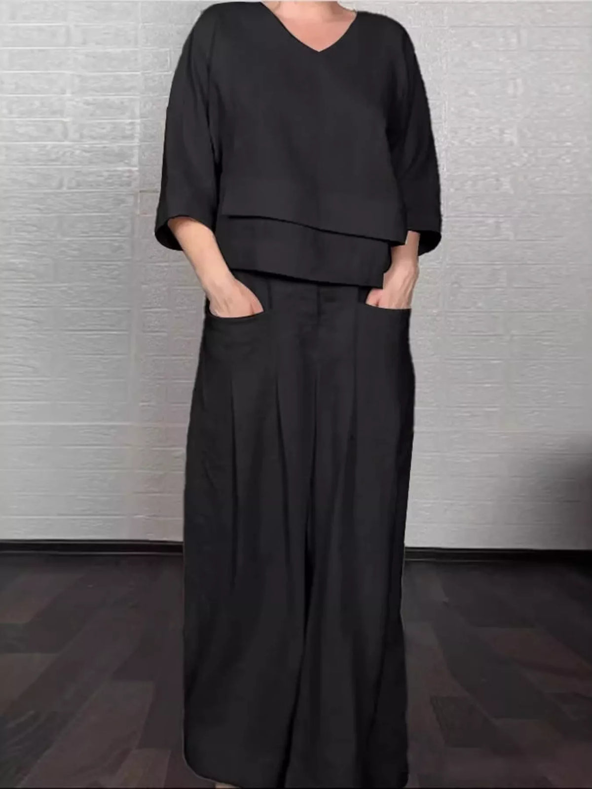 Plus size full V-neck long sleeve top and pants matching set by Trendsi, showcased in a stylish, comfortable fashion ensemble.