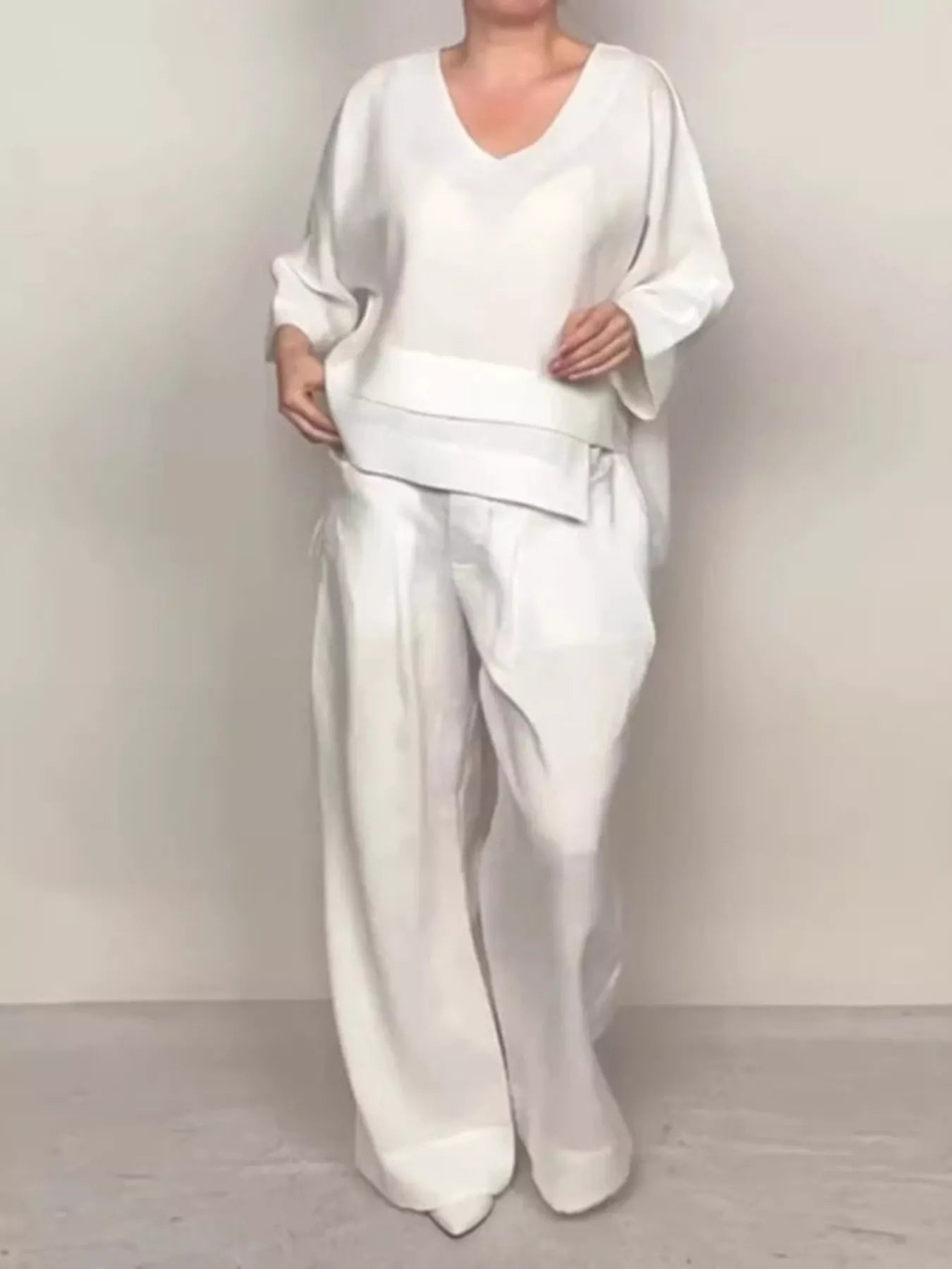 Plus size full V-neck long sleeve top and matching pants set by Trendsi, featuring comfortable fabric and relaxed fit.