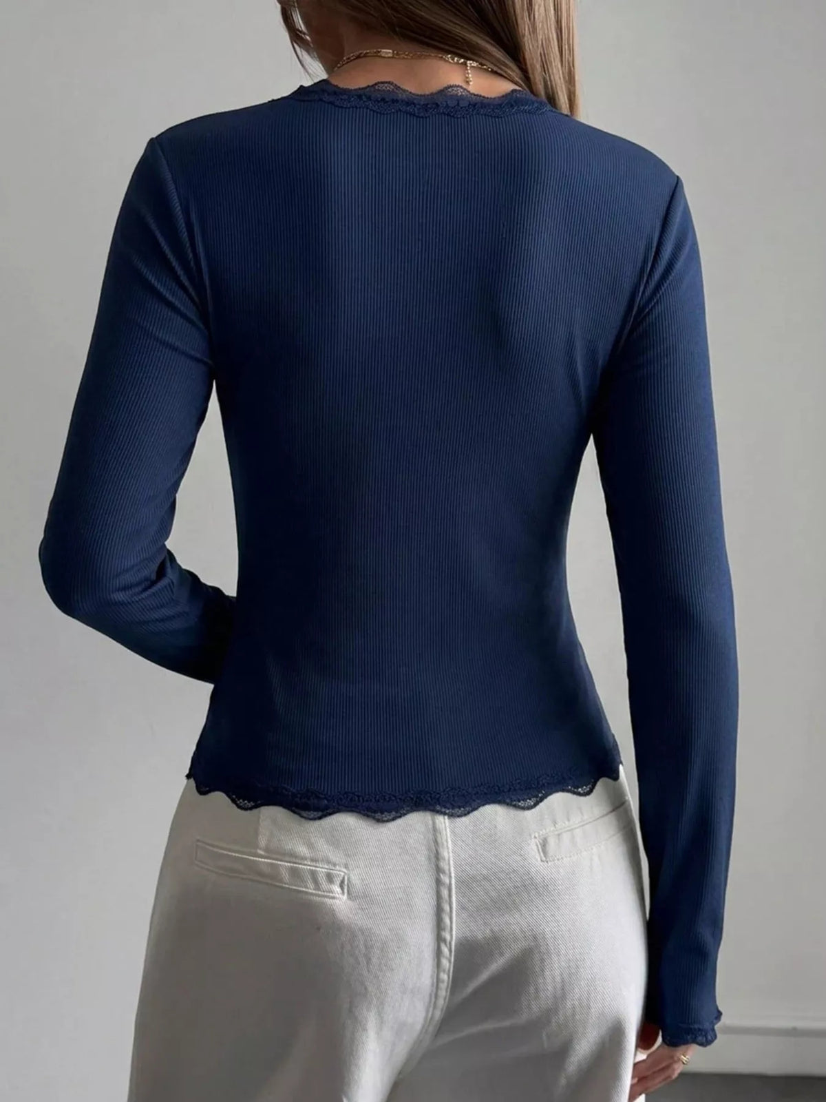 Ribbed long sleeve blouse with lace trim, V-neck, and fitted design, from Trendsi, shown in black with textured fabric details.