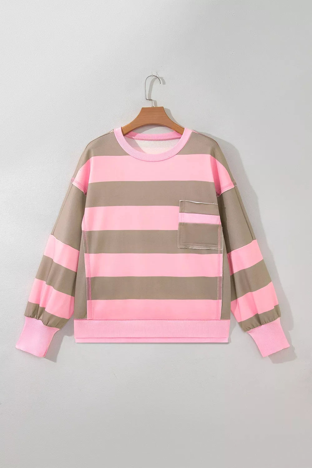 Oversized colorblock striped long sleeve sweatshirt by Trendsi with patch pocket and split hem, featuring bold, vibrant patterns.