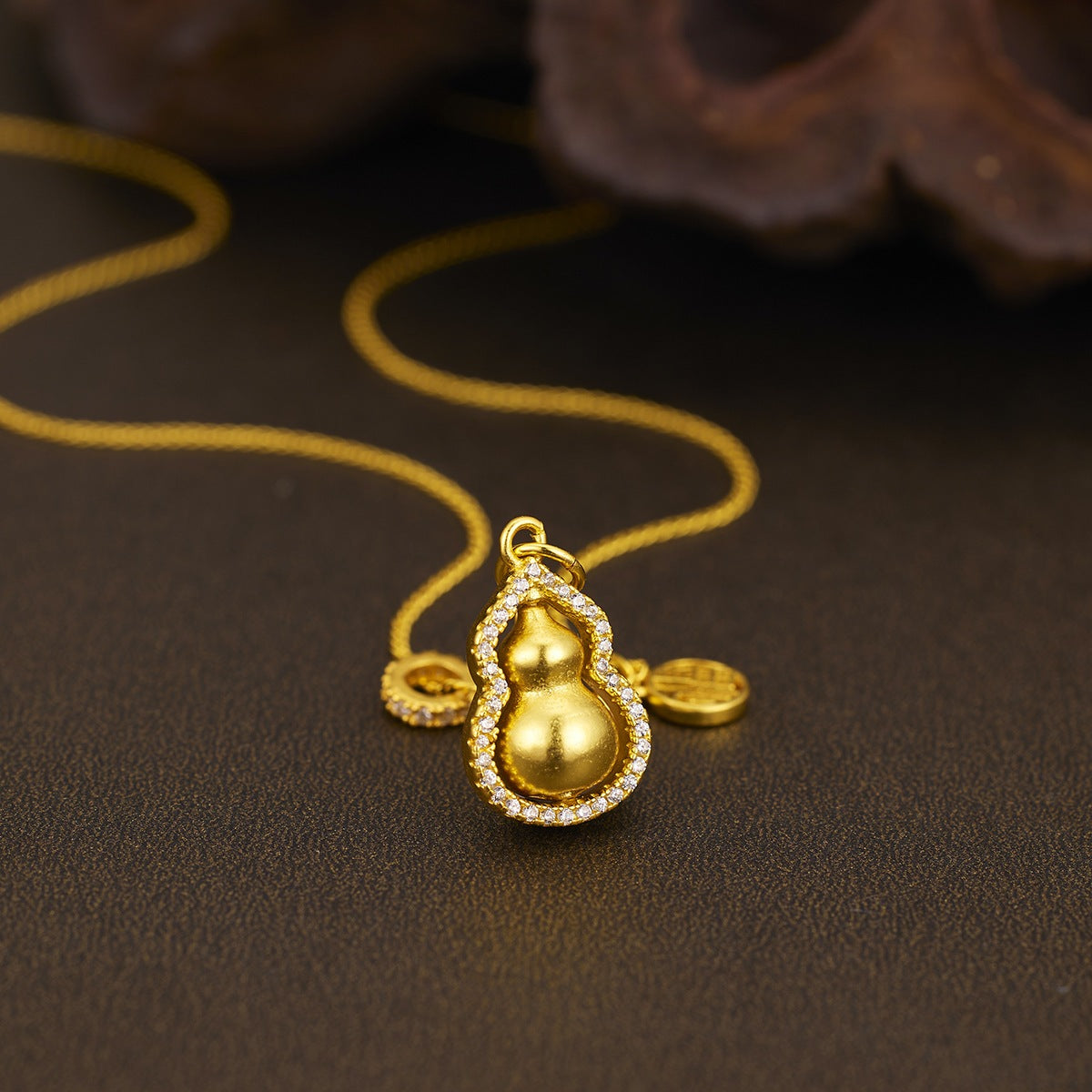 Gold-plated gourd pendant necklace with intricate detailing, featuring a sleek chain for a stylish accessory.