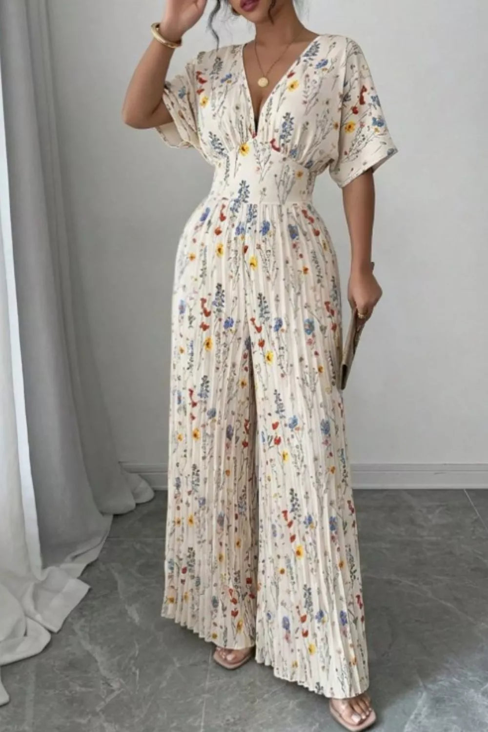 Floral print wide-leg pleated jumpsuit from Plush Fashion Hub, showcasing its stylish design and vibrant floral pattern.