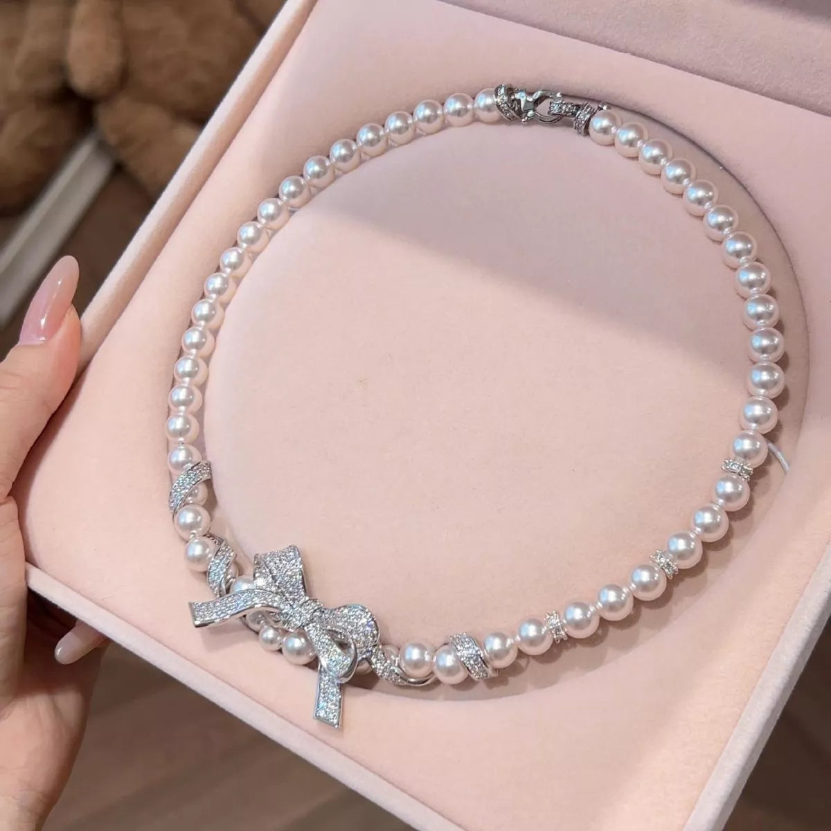 Pearl necklace with bow pendant from Plush Fashion Hub featuring elegant white pearls and a delicate bow charm.