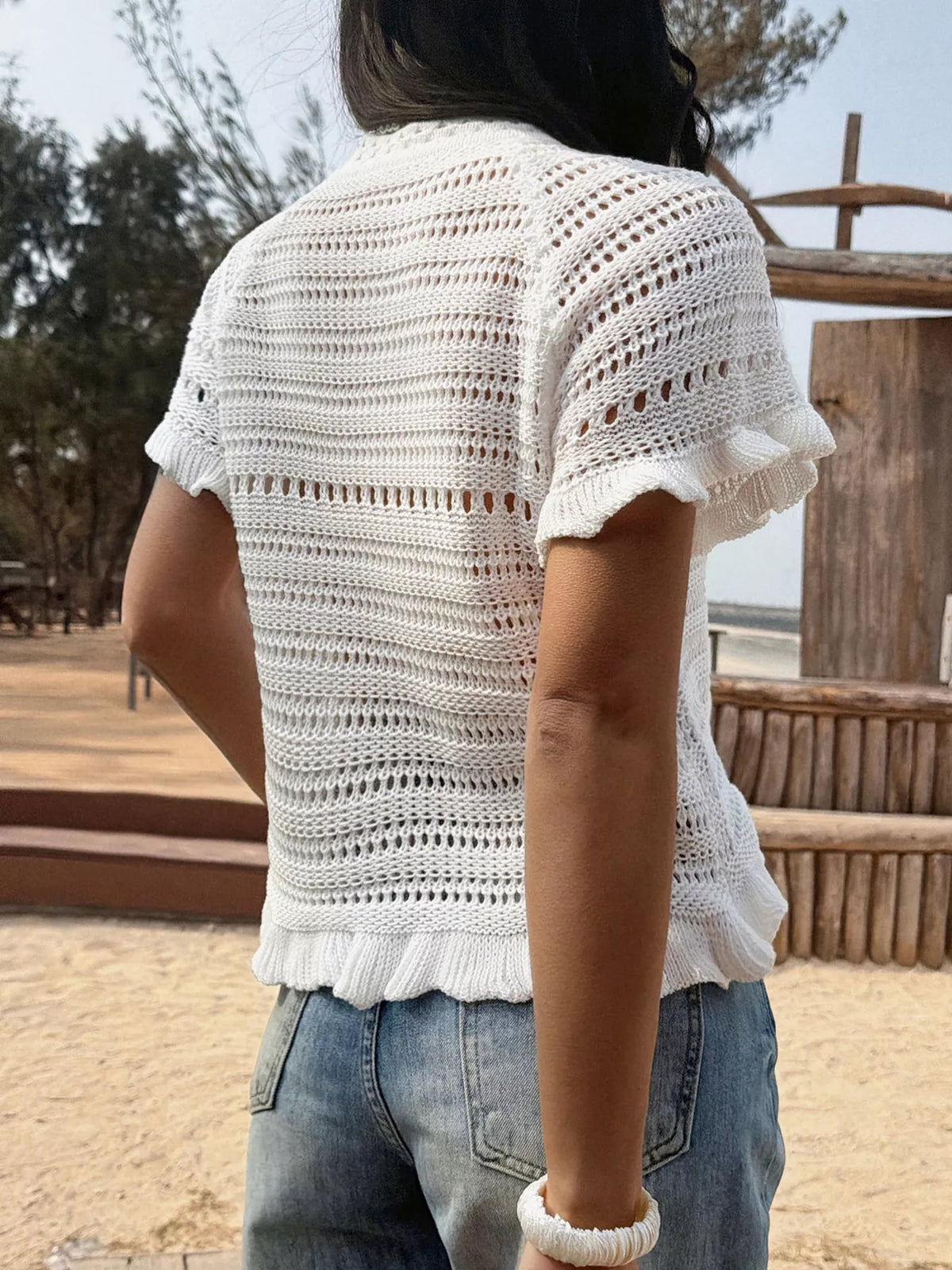Openwork ruffled hem knit top by Plush Fashion Hub featuring a stylish, lightweight design with intricate openwork and ruffled details.