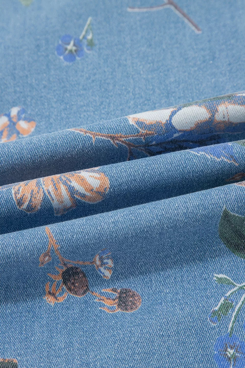 Floral print wide-leg jeans by Trendsi featuring a relaxed fit, high waist, and vibrant floral pattern in denim fabric.