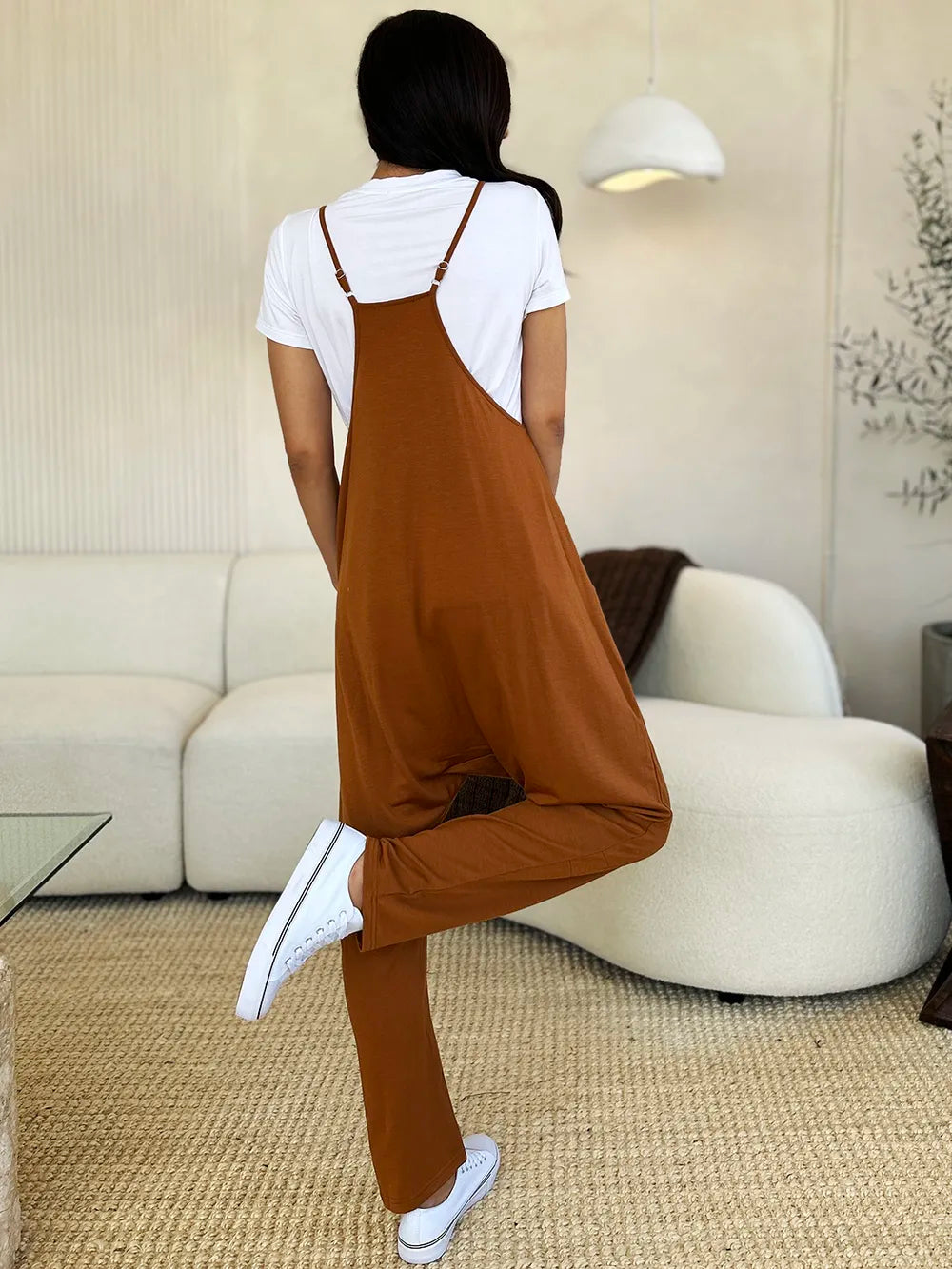 Women’s sleeveless V-neck wide-leg jumpsuit from Plush Fashion Hub with pockets, stylish and comfortable for casual wear.