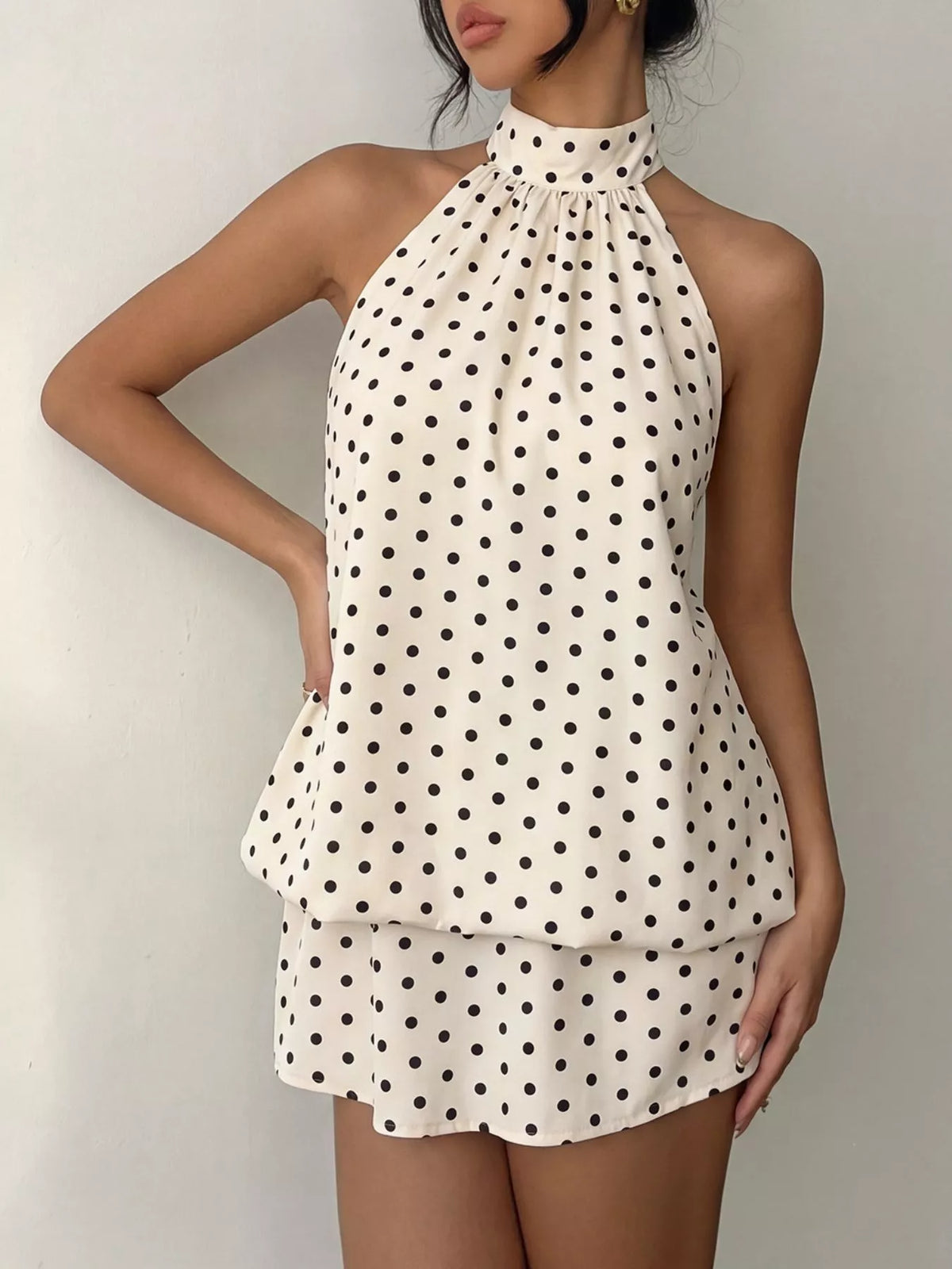 Polka dot halter neck mini dress by Plush Fashion Hub, featuring a fitted bodice and playful polka dot pattern.