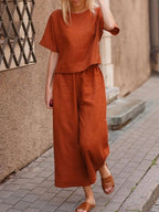 European and American women's linen casual two-piece suit with loose fit and solid color, featuring a stylish top and matching bottoms.