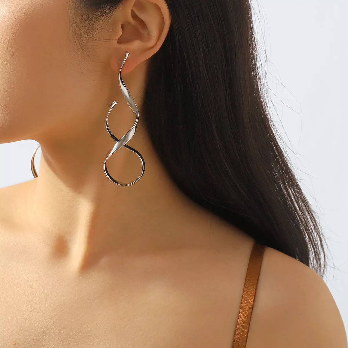 Silver alloy spiral drop earrings with a sleek, modern design, crafted by Plush Fashion Hub, hanging gracefully against a neutral background.