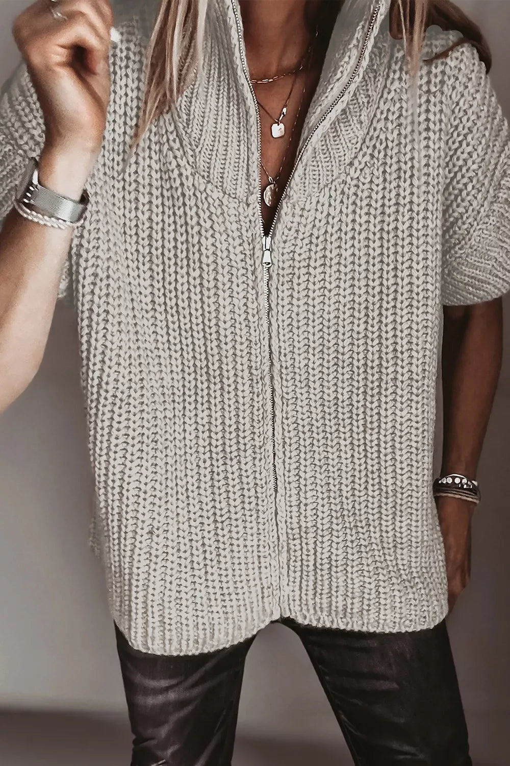 Solid color short sleeve knit sweater with high neck and zipper detail, designed by Trendsi.