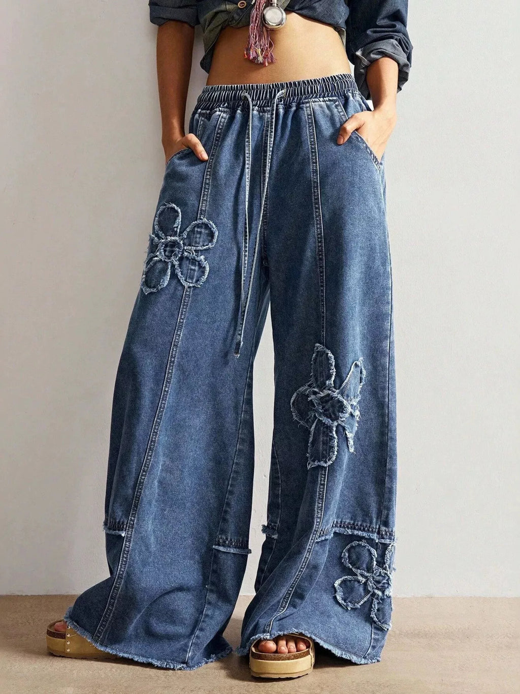 Wide leg jeans with floral appliques from Shopimist, featuring a relaxed fit and decorative floral embroidery on denim.