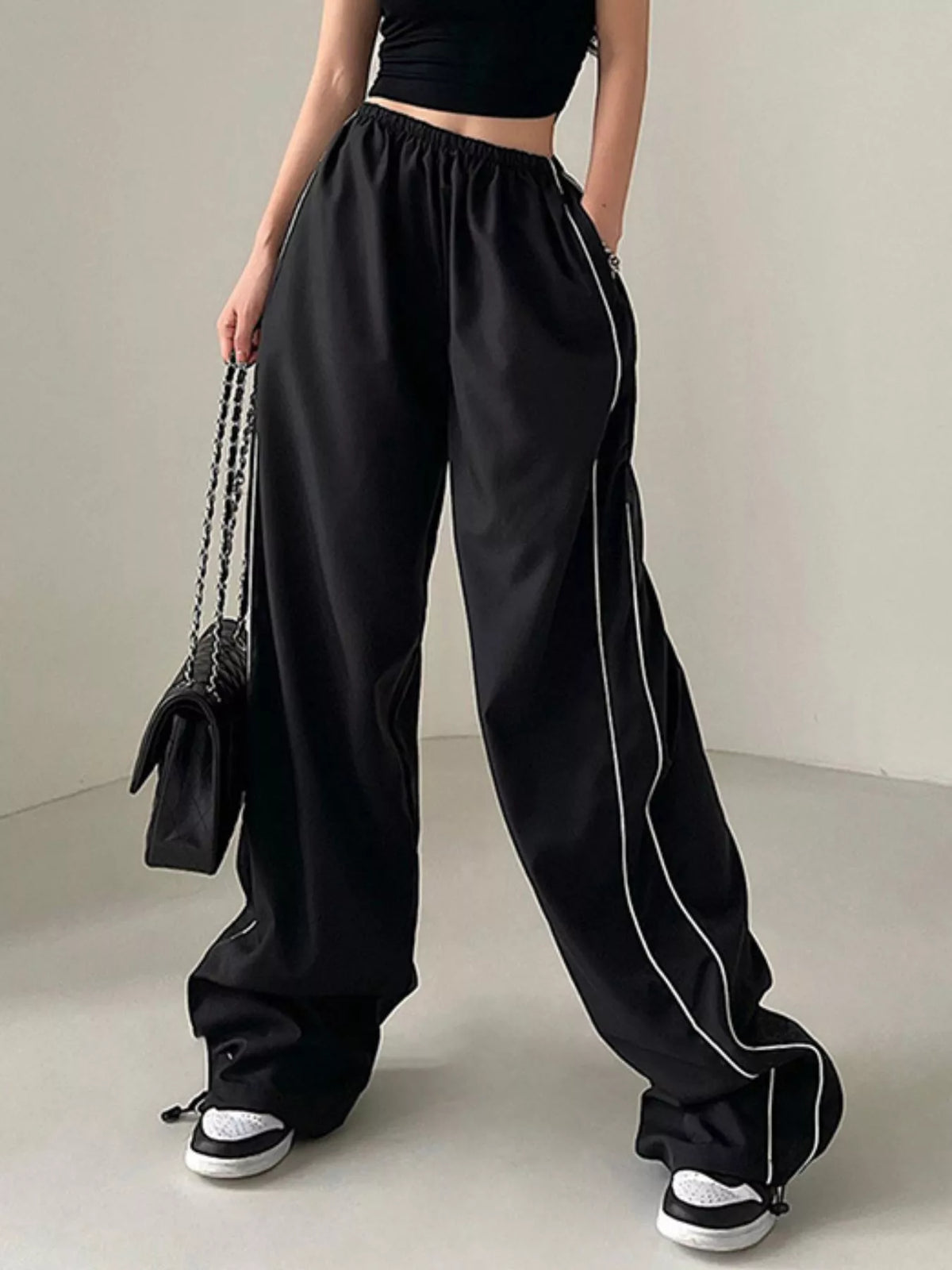 Women's lightweight high-rise wide-leg pants with elastic waist, stylish dress by Plush Fashion Hub, shown in a natural pose.